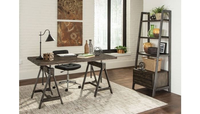 Rustic home office desk with metal accents, black swivel chair, decorative items, and a ladder-style shelving unit against a bright wall, reflecting industrial style and modern farmhouse aesthetics.